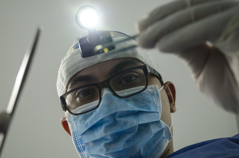 Dentista con mascherina chirurgica per proteggere il paziente